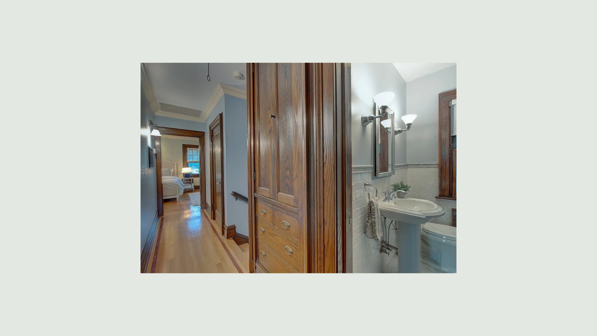 Primary bathroom with white double vanity, framed mirrors and landscape artwork